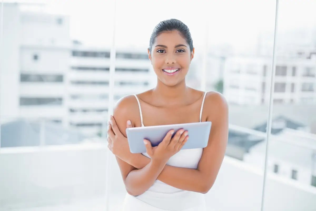 Smiling toned brunette using tablet